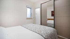 A bedroom with a bed, a window, and a wardrobe. - Apartment 'L'Aia - 2' with Shared Pool, Wi-Fi and Air Conditioning (Monopoli)