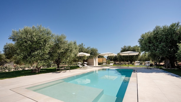 A rectangular swimming pool with a clear blue water surface, surrounded by a light-colored tiled deck. - Apartment 'L'Aia - 2' with Shared Pool, Wi-Fi and Air Conditioning (Monopoli)