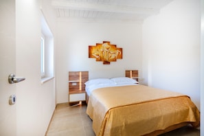 Une chambre à coucher avec un lit, un tableau, une fenêtre et une porte.