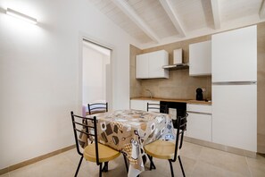 A compact kitchen with white cabinets, a built-in oven, and a coffee maker.