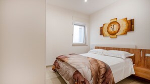A bedroom with a bed, a window, and a wall-mounted artwork. - Apartment 'L'Aia - 4' with Shared Pool, Wi-Fi and Air Conditioning (Monopoli)