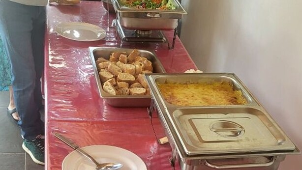 A buffet table with various food items, including a tray of bread, a casserole dish, and a salad. - Spacious villa in Grand Coude with wheelchair access (Saint-Joseph)