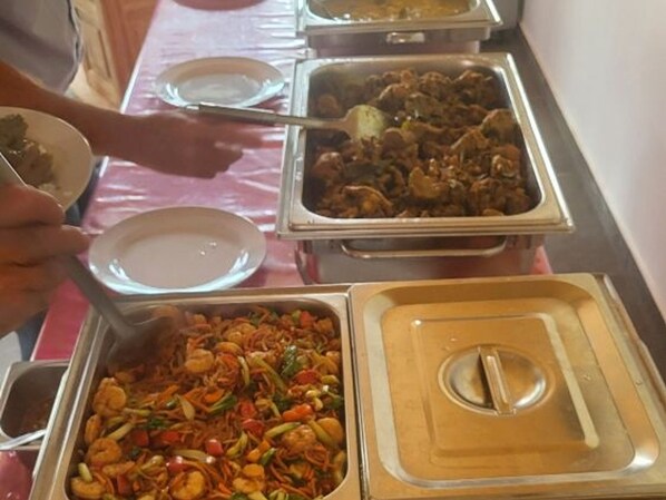 A buffet table with various food dishes.
