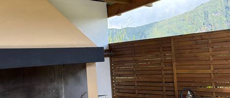 An outdoor kitchen area with a built-in grill, a sink, and a wooden fence.