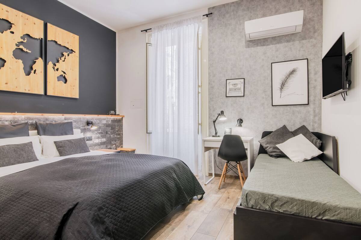 Un dormitorio moderno con dos camas, un escritorio y un televisor.