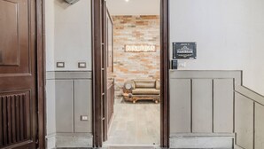 Ingresso di un hotel con una porta in legno, un neon con scritto 