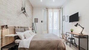 Una camera da letto moderna con un letto grande, una scrivania e un televisore.