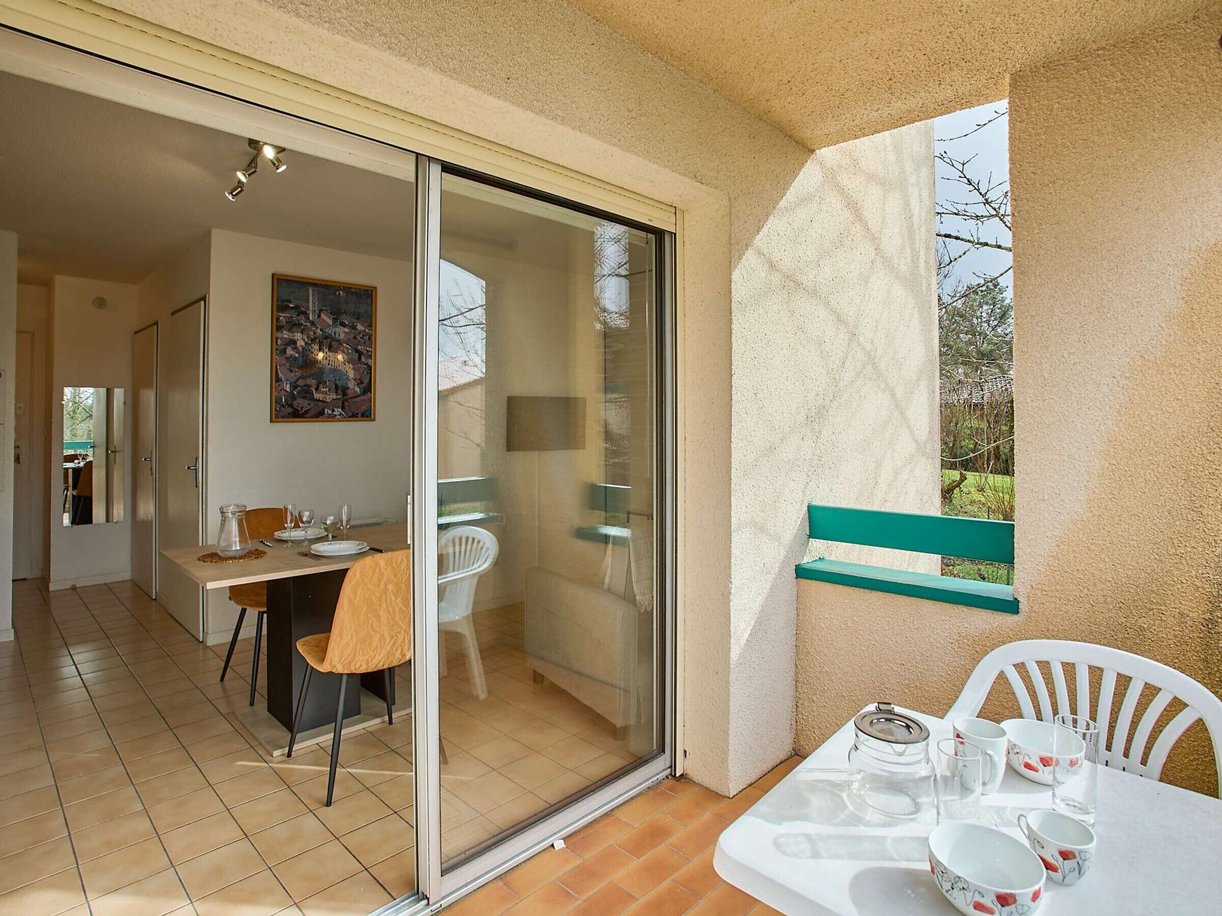 Un balcón con mesa lista para comer, una silla y un banco.