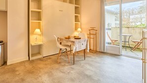 A modern room with a dining table, chairs, and a built-in shelving unit.