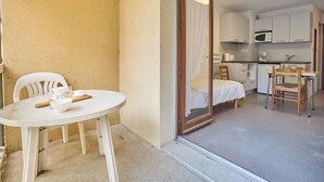 A compact room with a dining area, kitchenette, and a bed with a canopy. - Quiet studio with Wifi and parking in Barbotan-les-Thermes (Barbotan-les-Thermes)