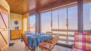 A dining area with a wooden table set for four, surrounded by wooden chairs. - Apartment T2 with porch and pets allowed (Barbotan-les-Thermes)