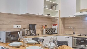 A modern kitchen with a wooden countertop, a coffee maker, a toaster, and a dishwasher. - Spacious renovated T2 with balcony, wifi and pets allowed in Barbotan-les-Thermes (Barbotan-les-Thermes)