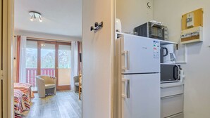 A compact kitchen with a refrigerator, microwave, and coffee maker.
