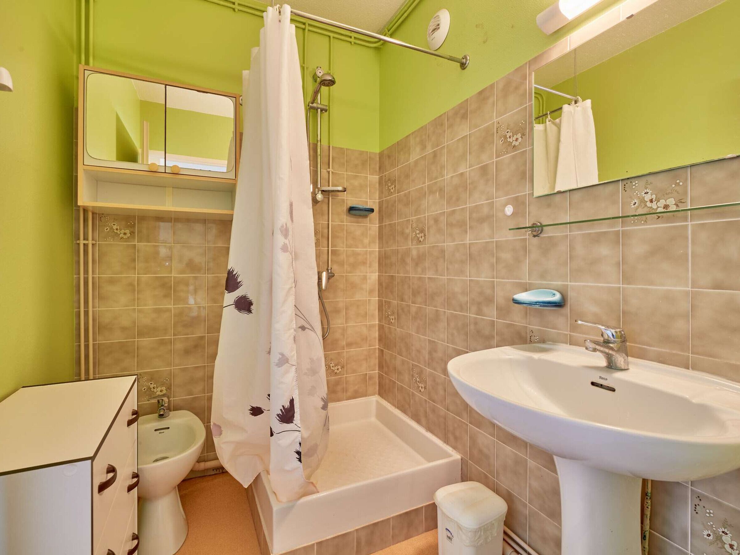 Een badkamer met een douche, toilet en wastafel.