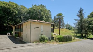 Un petit bâtiment d’un seul étage, doté d’un toit en tuiles, d’un balcon et d’un petit jardin.