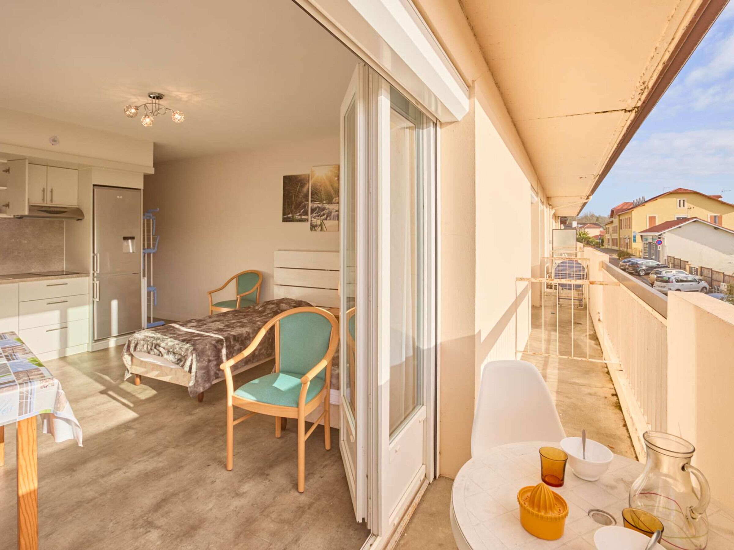Un balcon avec une table, des chaises et un petit coin cuisine.
