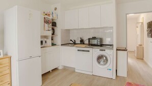 A compact kitchen with a washing machine, microwave, and toaster. - Renovated apartment in Hendaye with air conditioning and parking (Hendaye)