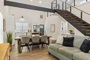 A modern interior with a staircase, dining area, and a sofa with cushions. - Secluded 3BR Cabin, Lake Access & Resort Perks (Westminster)