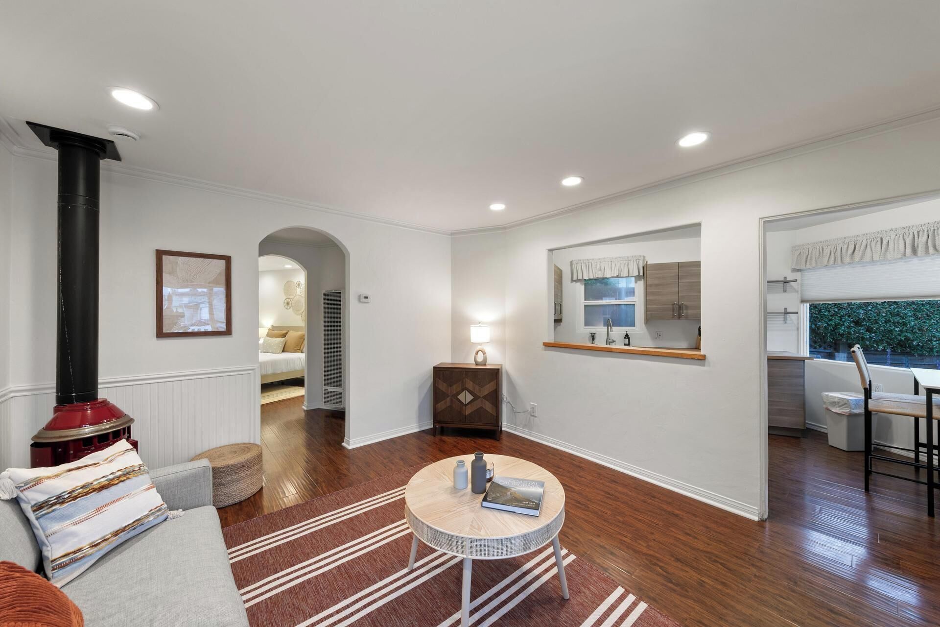 A modern living room with hardwood flooring, a round coffee table, a sofa, and a fireplace.