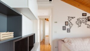 A modern room with a bed, a TV, and a wall with geometric art.