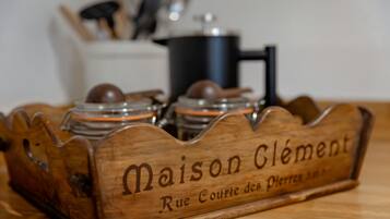Ein Holztablett mit Gläsern, auf denen 'Maison Clement Rue Courte de Pierrette' steht.