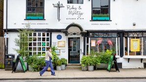 A white building with a sign reading "Ruby & Montys Kitchen & Bar" and "Evenings - Pizza & Pasta". - Stylish 16th century apartment in Petersfield town centre (Petersfield)