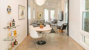 Ein modernes Interieur mit Essbereich, einer Couch und einem Fernseher.