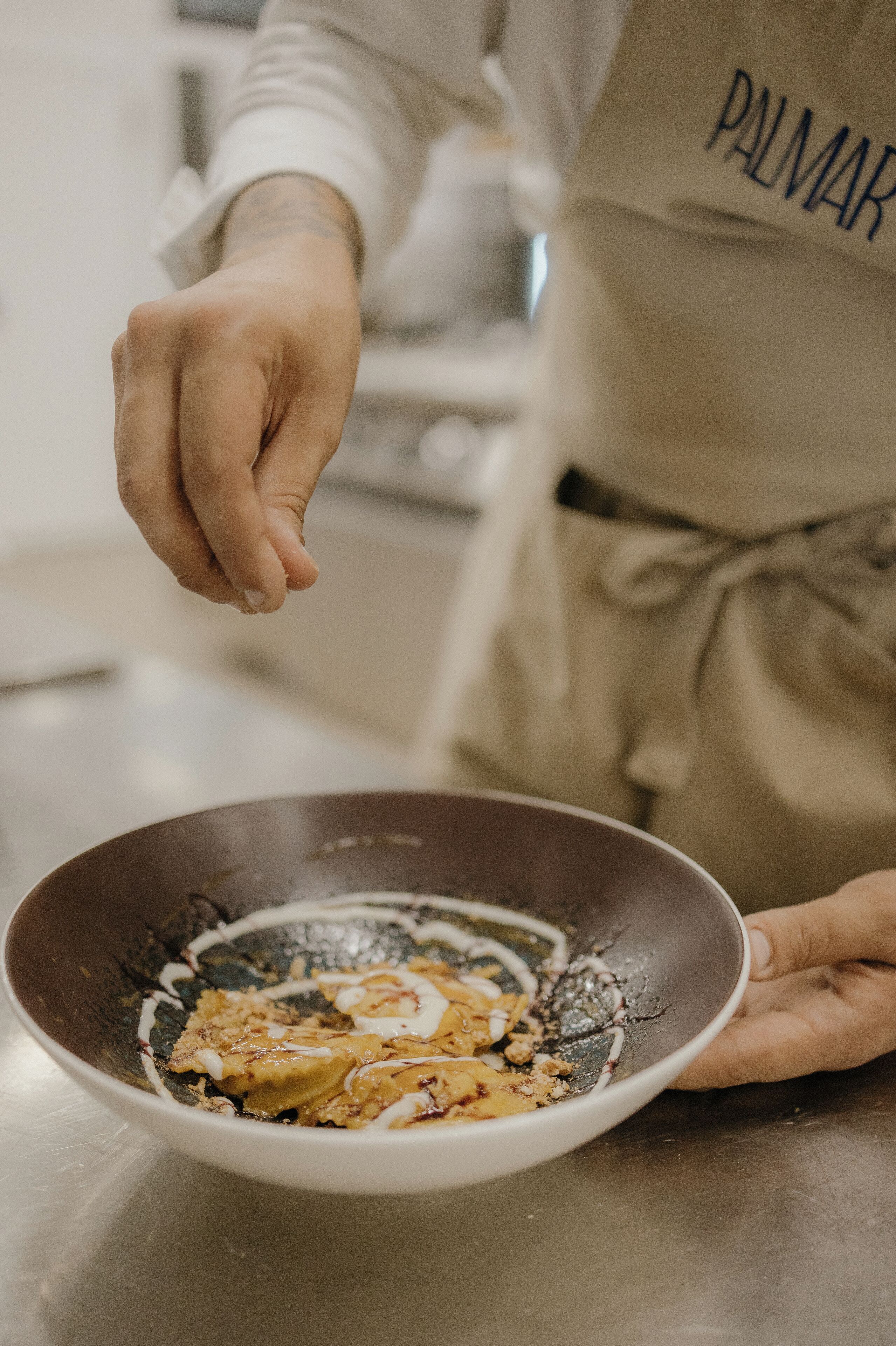 Una persona en la cocina preparando comida en un bol.