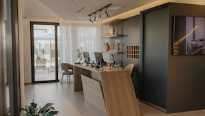 Une cuisine moderne dotée d’un îlot central intégré, d’un coin repas avec des chaises et d’une grande fenêtre offrant une vue dégagée.