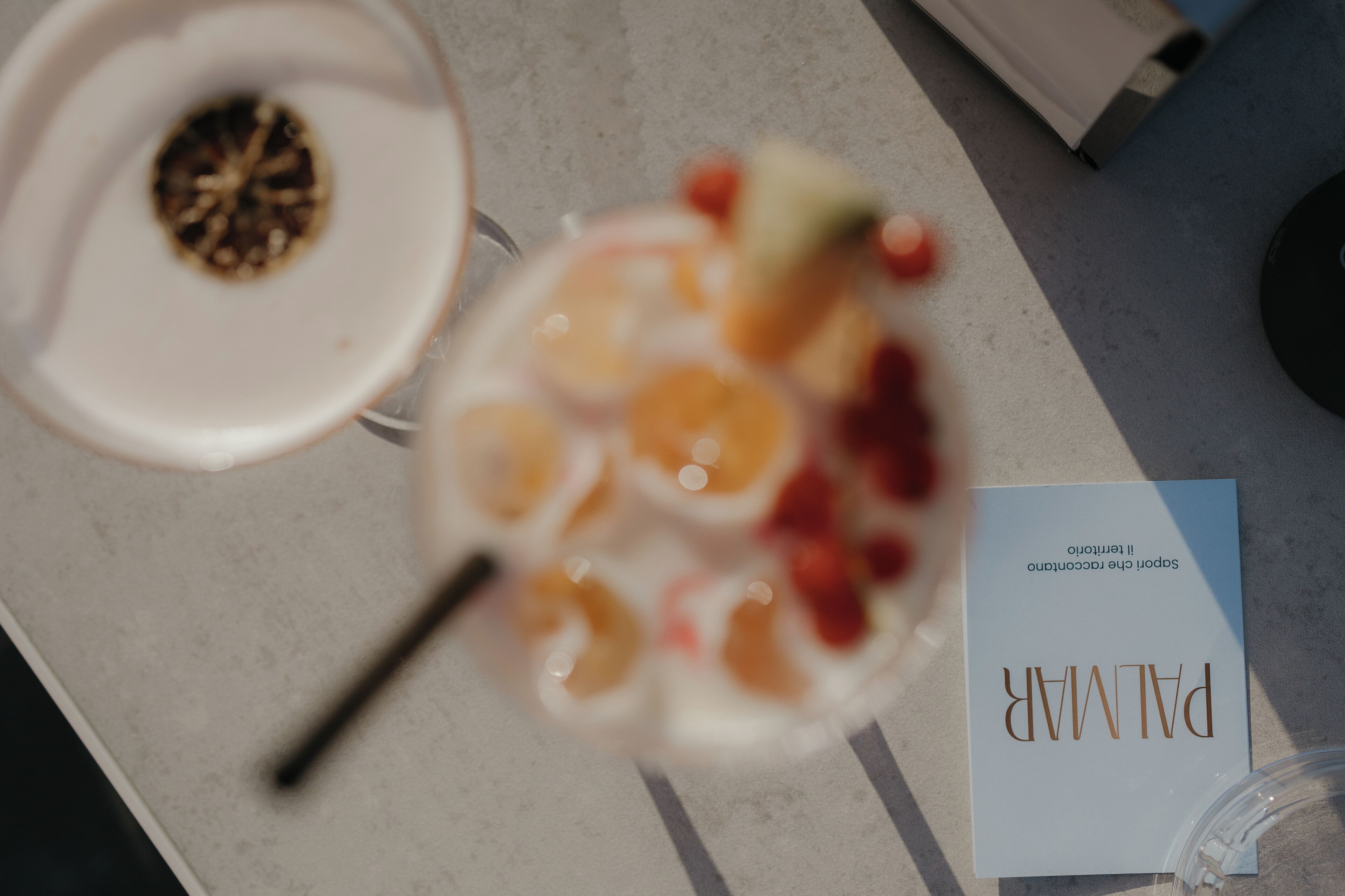 A table with a glass containing fruit, a white plate with a lid, and a booklet titled "PALMER".
