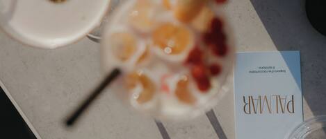A table with a glass containing fruit, a white plate with a lid, and a booklet titled "PALMER".