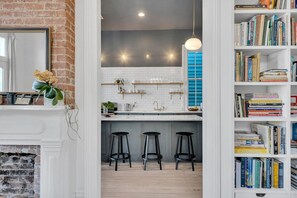 Une cuisine moderne avec un mur en briques, des carreaux de métro blancs et un îlot central doté de tabourets.