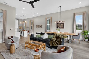 Uma sala de estar moderna com sofá, mesa de centro e área de jantar.