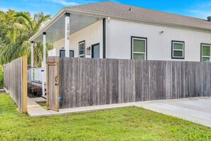 A single-story house with a covered porch, a wooden fence, and a well-maintained lawn.