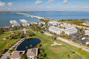 A coastal resort with a marina, golf course, and a long bridge in the background. - Coastal Living Journey | Golf Course. Outdoor Pool (Stuart)