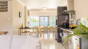Une cuisine moderne avec un coin repas, une grande fenêtre et une vue sur l’extérieur.