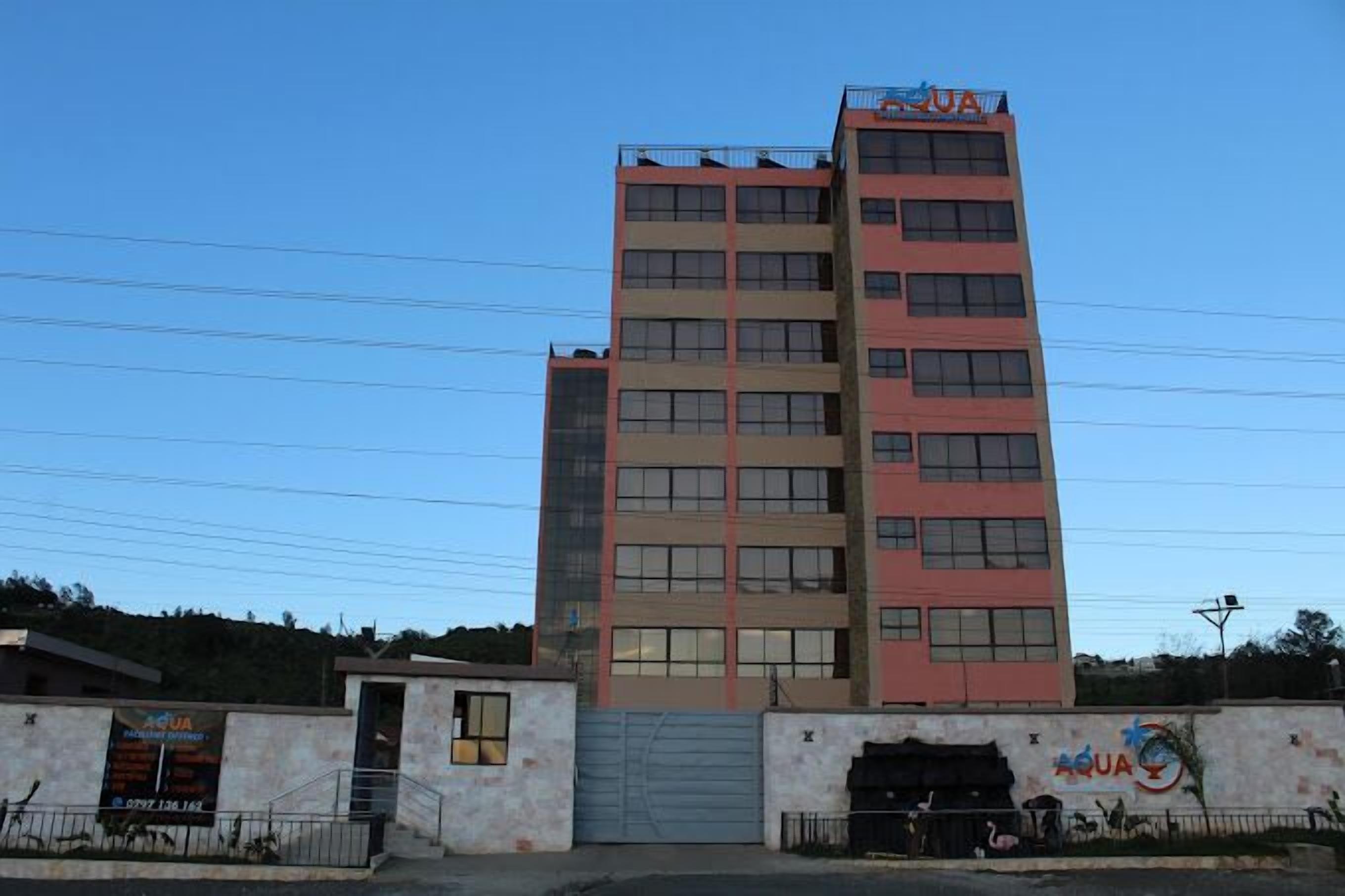 A multi-story building with a sign reading "AQUA" on the top.