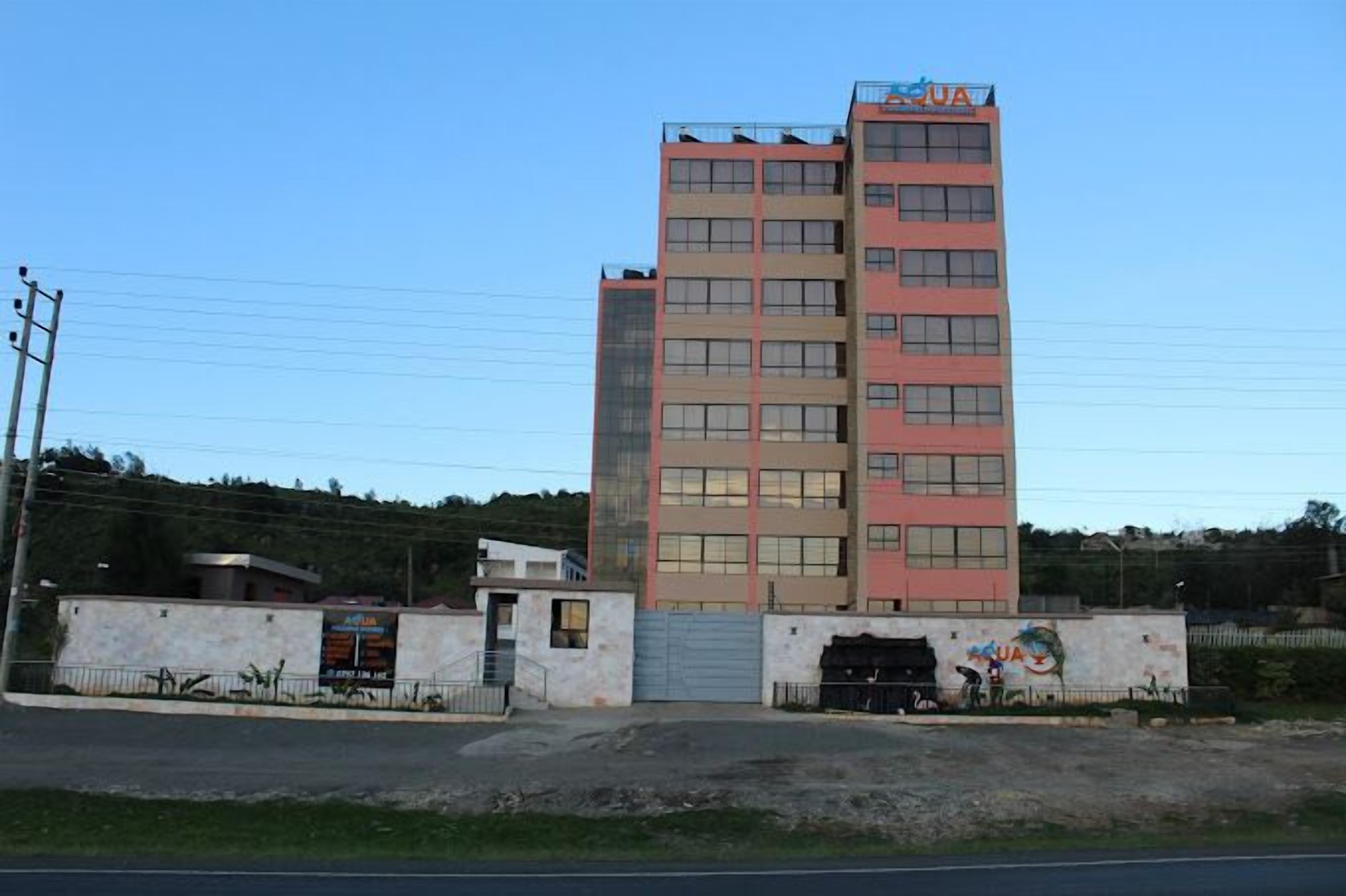 A multi-story building with a sign reading "AQUA" on top.