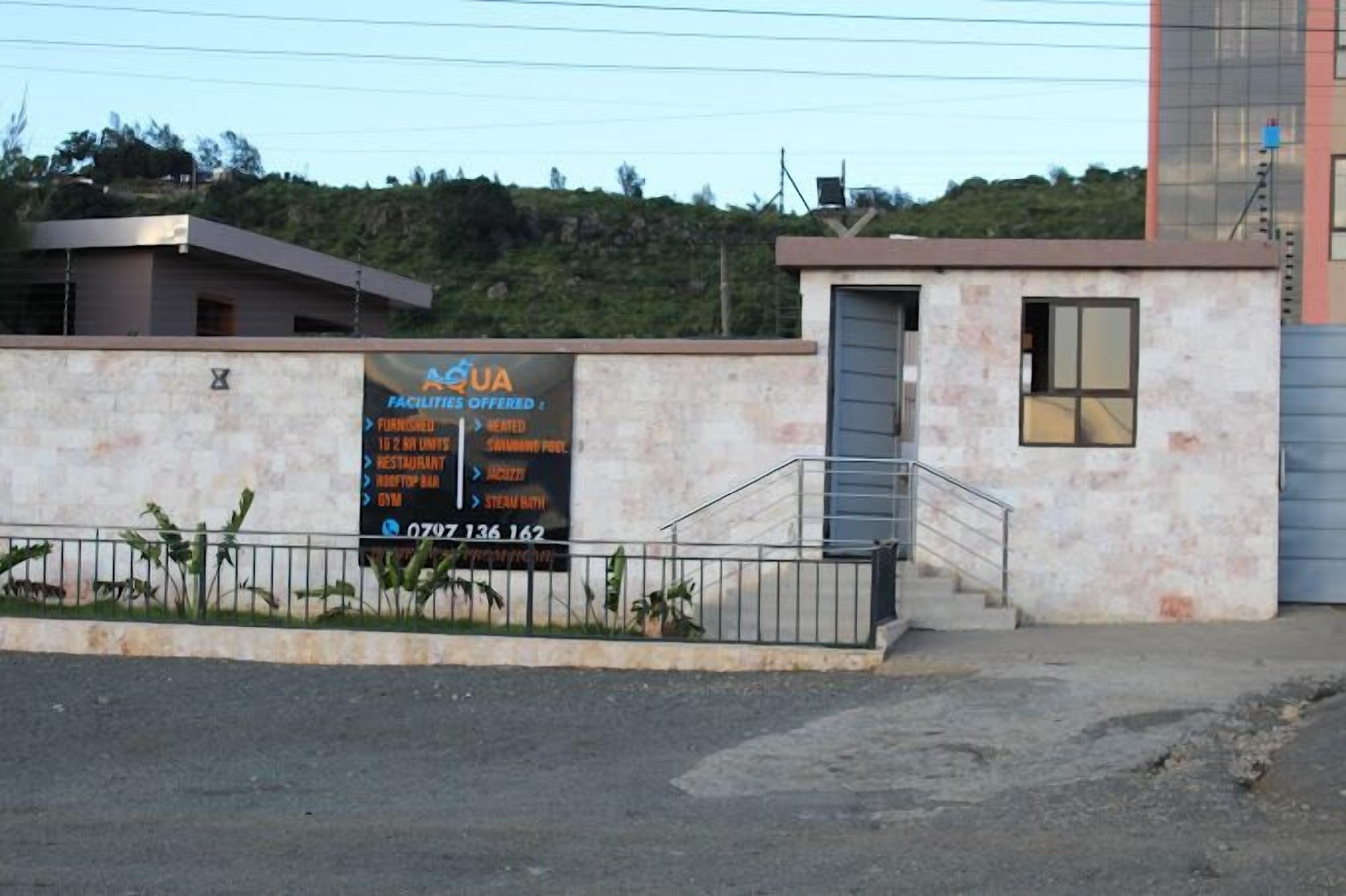 A signboard listing facilities including a restaurant, gym, and steam bath.