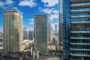 Un immeuble de grande hauteur doté de nombreux balcons et d’une architecture moderne, entouré d’autres immeubles de grande hauteur au sein d’un paysage urbain.