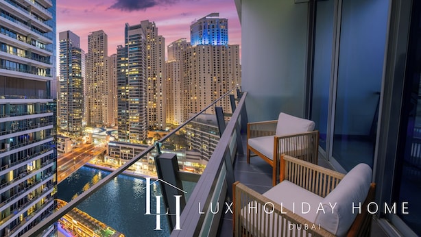 Un balcone con vista su un panorama urbano al crepuscolo, con grattacieli e un corpo d'acqua.