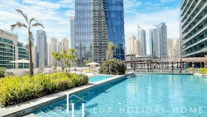 Una piscina con vista su alti palazzi e un hotel Niran sullo sfondo.
