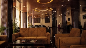 A modern lobby with leather sofas, a coffee table, and a reception desk. - RATNA HOTEL (Biratnagar)