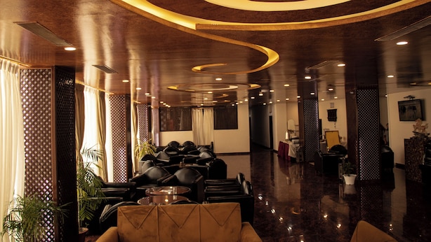 A modern lobby with a curved ceiling design, leather seating, and a polished floor. - RATNA HOTEL (Biratnagar)