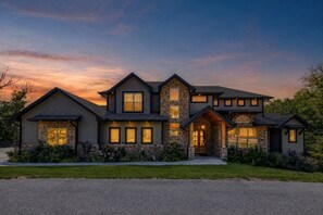 A two-story house with a stone facade, multiple windows, and a well-maintained lawn. - Rooms W/A View - Amazing Mountain Views (Sevierville)