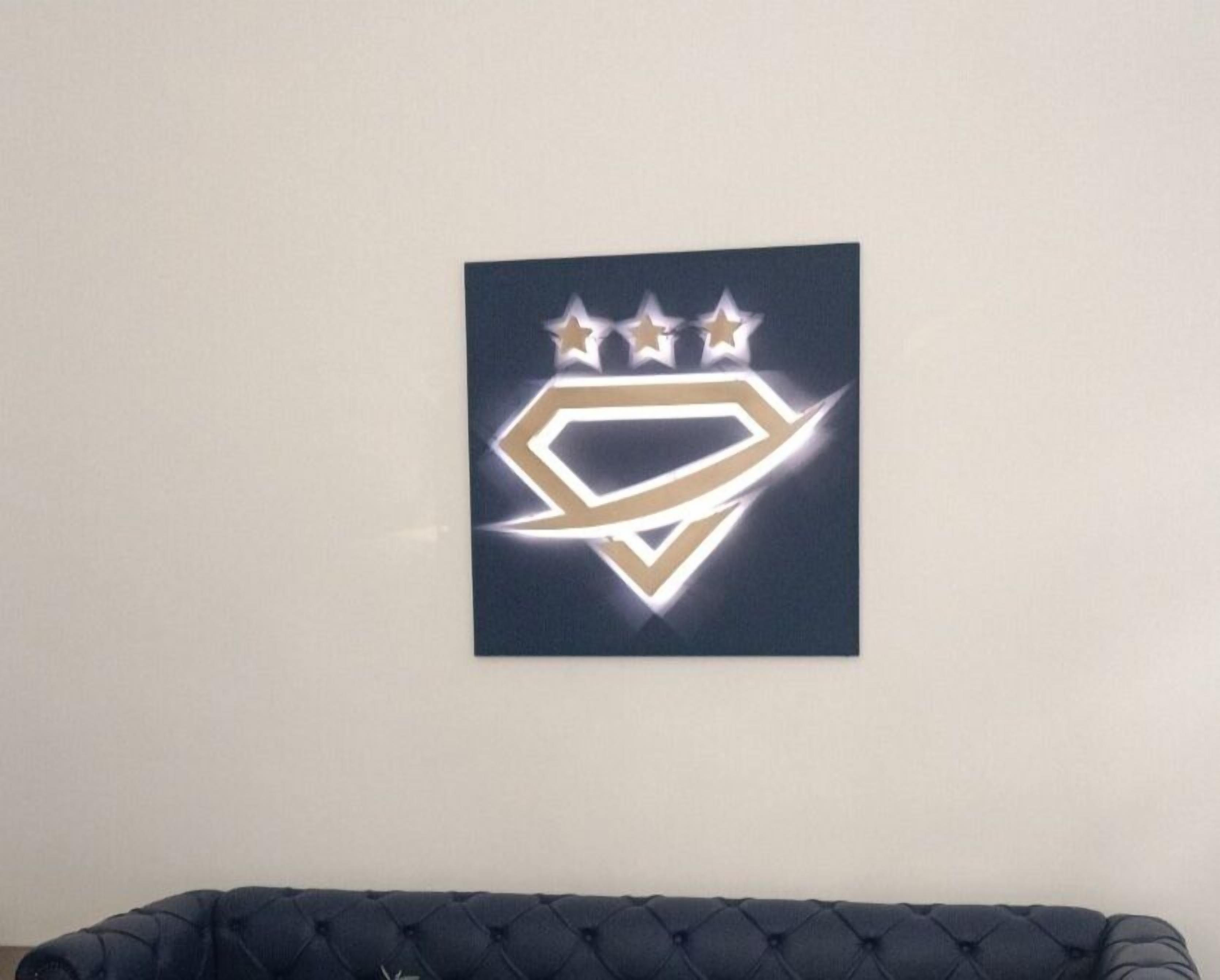 A wall-mounted logo with a diamond shape and three stars.