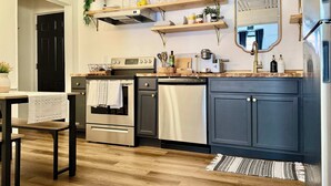 A modern kitchen with stainless steel appliances, wooden shelves, and a built-in oven. - Off Street Reserved Parking, Full Kitchen, Newly Renovated (Verona)