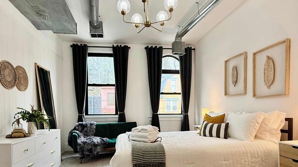 A bedroom with a bed, dresser, chair, and a ceiling fan. - Off Street Reserved Parking, Full Kitchen, Newly Renovated (Verona)