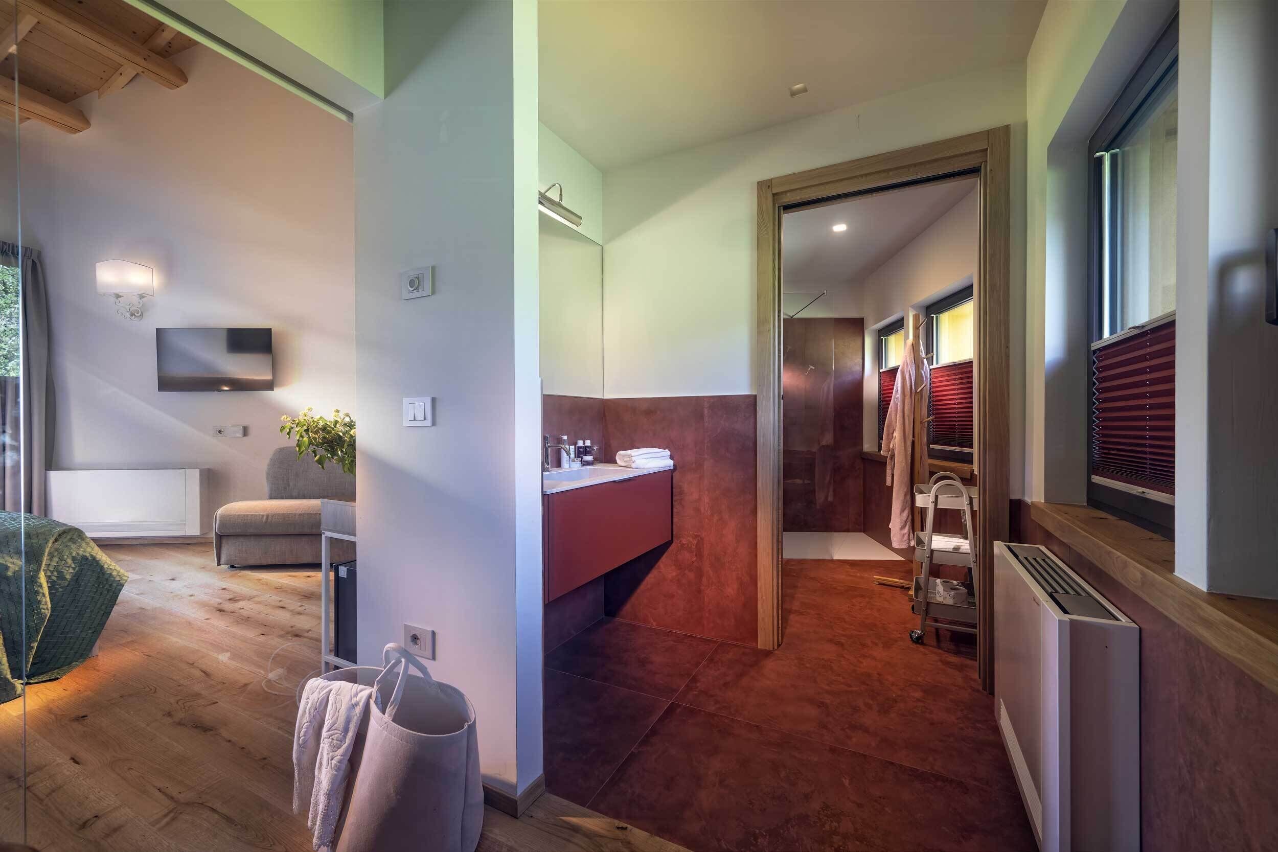 A modern bathroom with a vanity, towel rack, and a shower area.