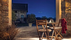An outdoor seating area with a table, chairs, and a basket. - Agriturismo Villa di Modolo (Belluno)